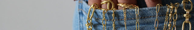 Gold chains flowing from the back pocket of denim jeans.